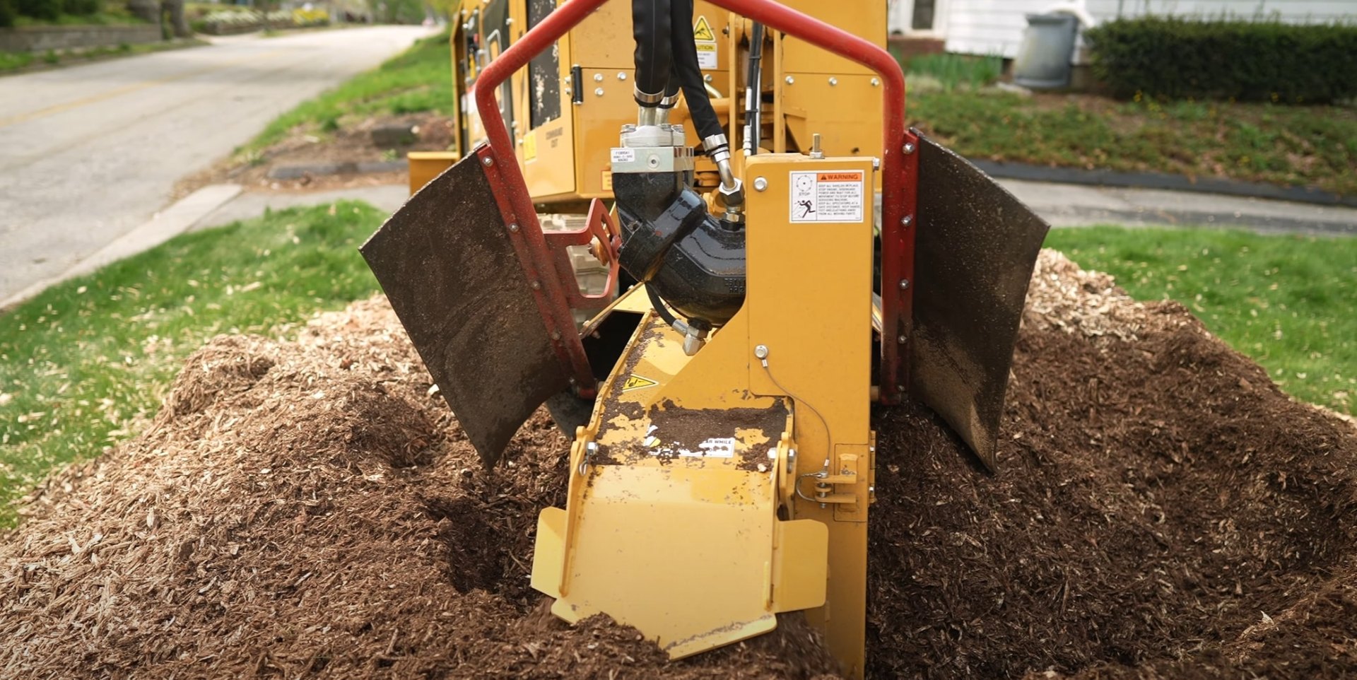 Complete Stump Grinding and Removal Professional stump grinding equipment removing tree stump in residential yard